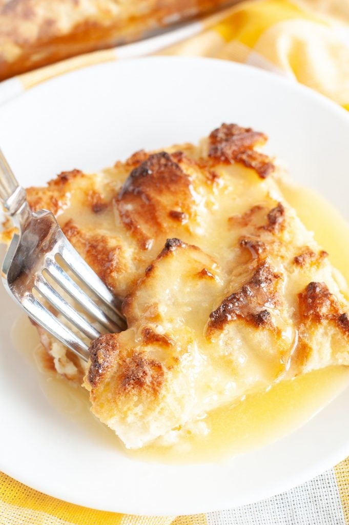 Bread Pudding on a plate with amaretto sauce and a fork