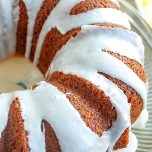 Bundt cake with icing on cake stand.