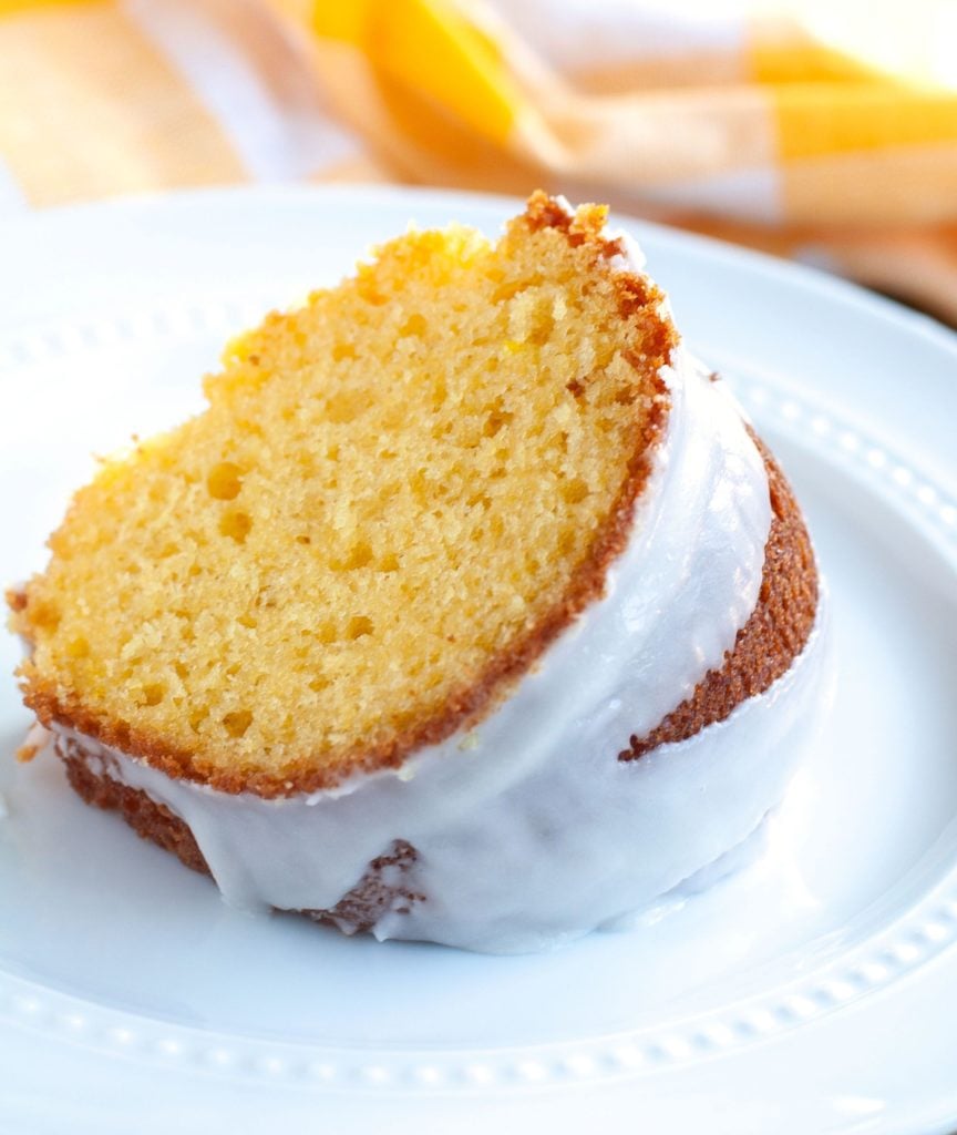 Slice of Apricot Nectar Cake on a white plate and a yellow napkin