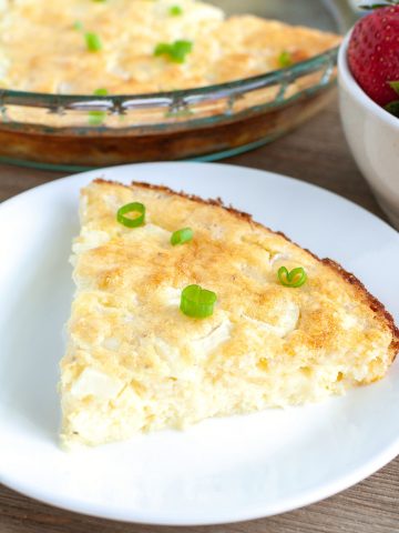 Quiche with green onion on a plate.