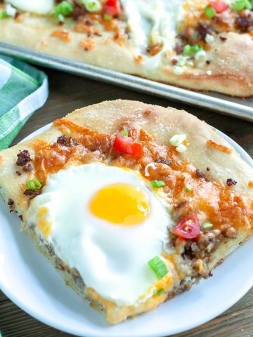 Piece of breakfast pizza on a plate.