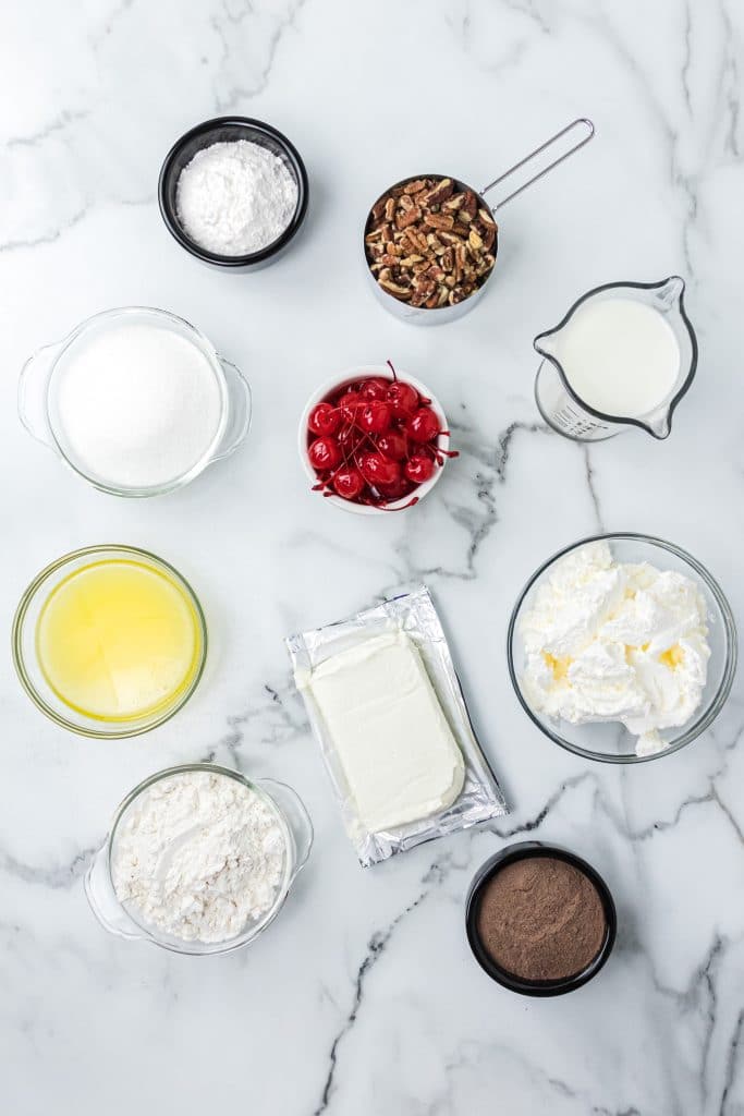 Bowl of melted butter, cool whip, flour, cherries, pecans, and pudding mix.