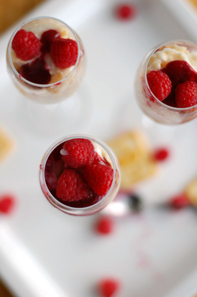 Looking down into champagne flute with raspberries on top of parfait