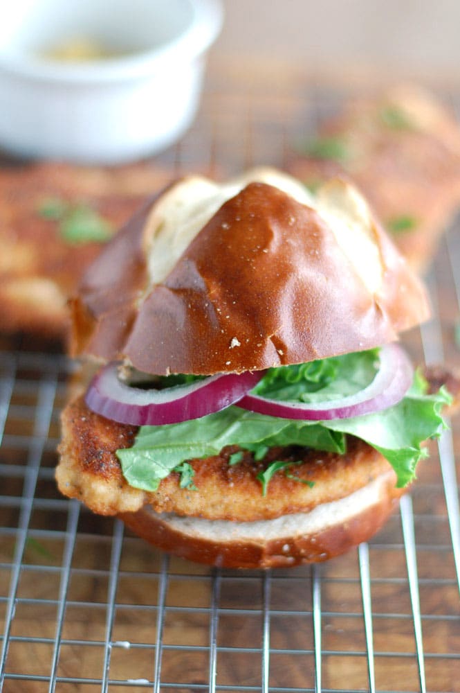 chicken schnitzel sandwich on a pretzel bun on a wire rack