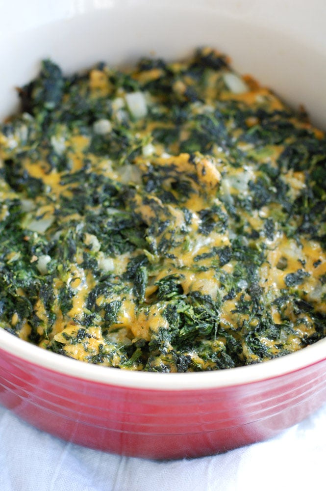 Deviled spinach in a red casserole dish