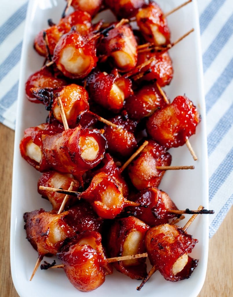 water chestnuts wrapped in bacon on a serving dish