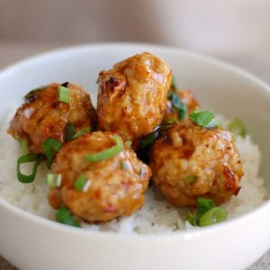 Chicken meatballs on rice in bowl.