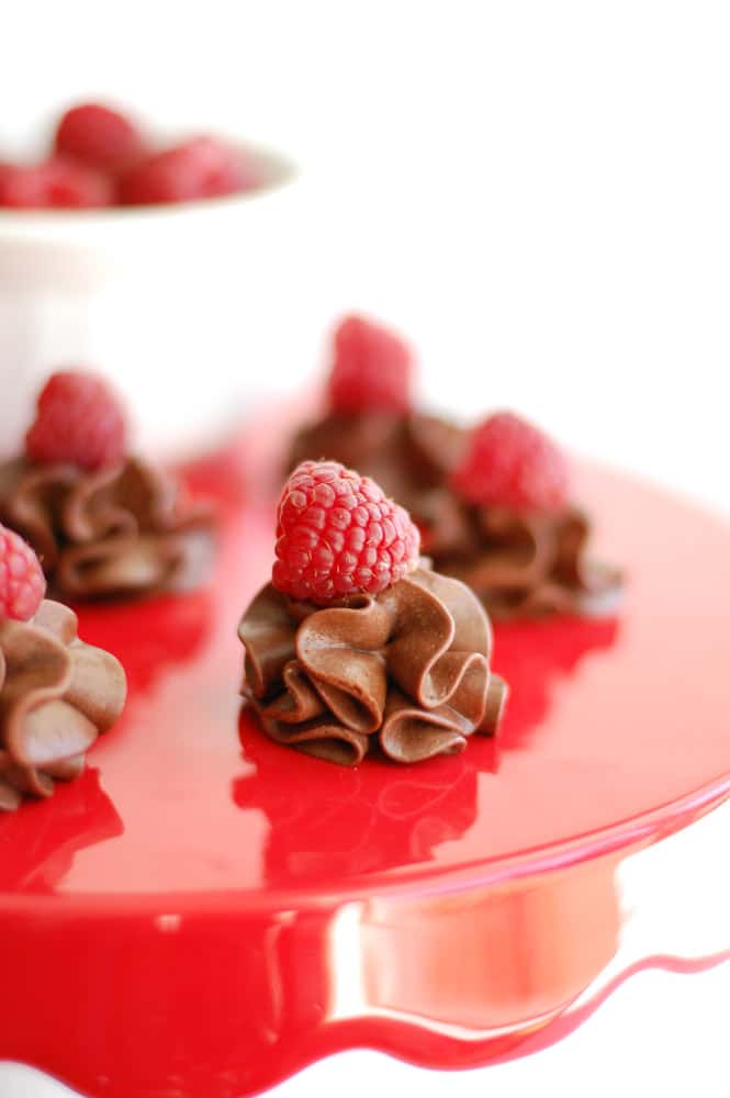 chocolate raspberry truffles on a red cake stand