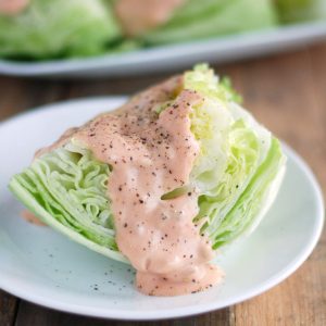 Wedge of lettuce with Thousand Island dressing.