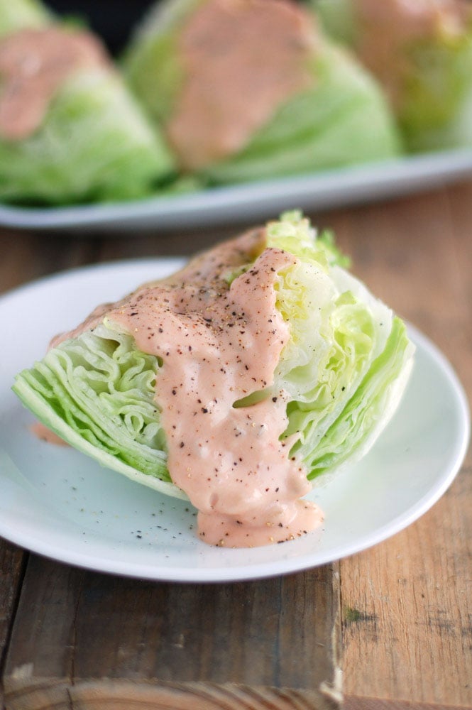 Lettuce Wedge with Homemade Thousand Island Dressing on a white plate