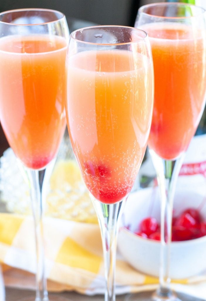 3 glasses of blushing mimosas with cherries
