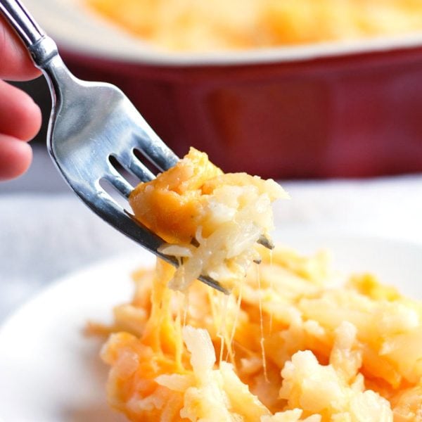 Fork scooping up hash brown casserole.