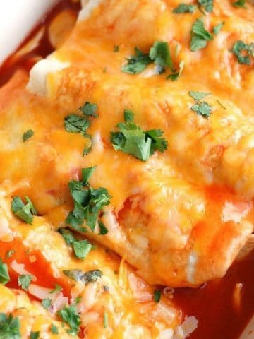 Enchiladas in baking dish topped with cheese