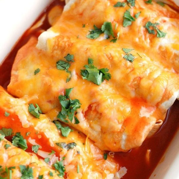 Enchiladas in baking dish topped with cheese
