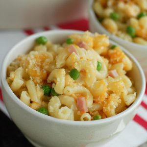 Macaroni and Cheese with ham and peas in bowl.