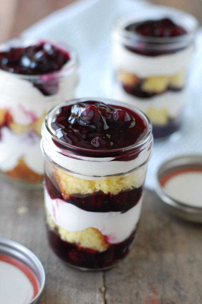 Blueberry Trifle layers of lemon cake, blueberry pie filling, and cream are assembled in Mason jars to make a delicious and portable dessert.