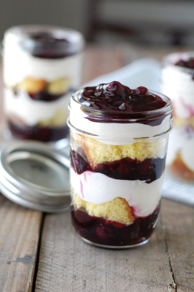 Jar filled with blueberry and cake dessert. 