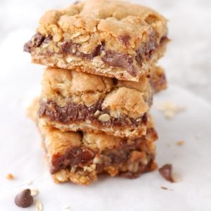 Oatmeal chocolate bar squares stacked on table.