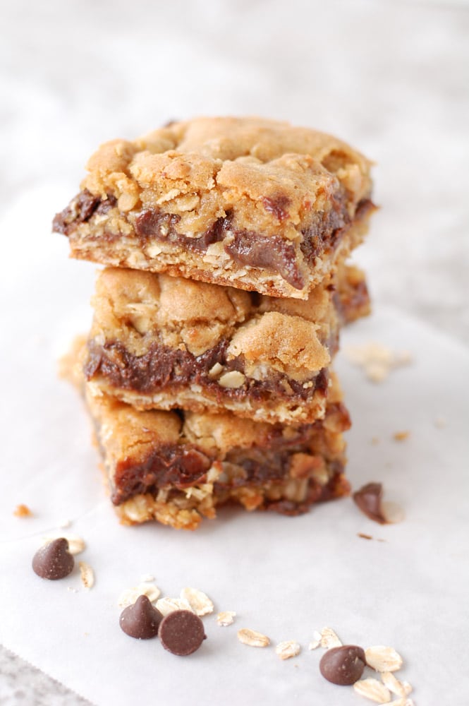 Oatmeal chocolate bar squares stacked on table. 