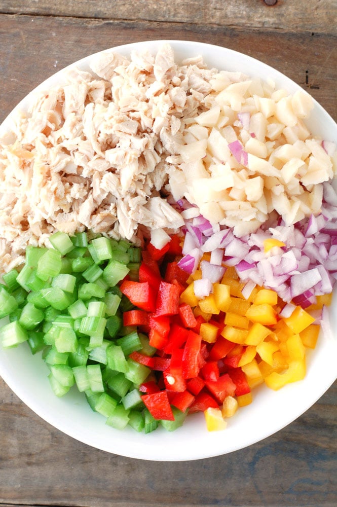 Shredded chicken, water chestnuts, red onion, bell peppers and celery in a bowl
