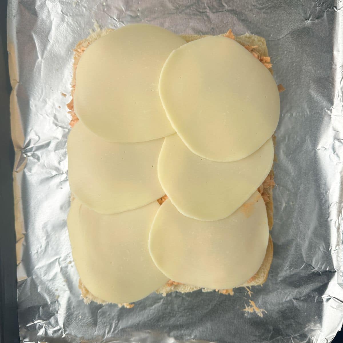Sliced provolone over rolls. 