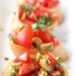 Sliced with topped with olives and tomatoes.