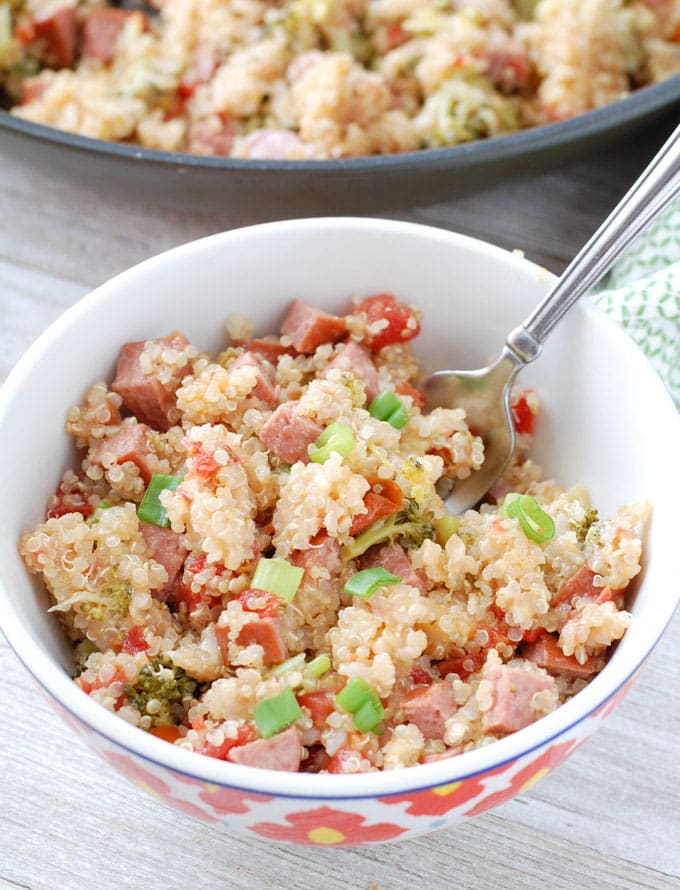 Bowl of quinoa, sausage and onions with a fork. 