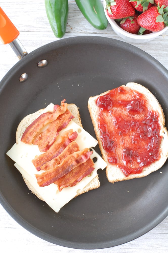 This Strawberry Jalapeno Bacon Grilled Cheese Sandwich is a crunchy, gooey combination of savory, sweet, and salty with just a touch of heat. To the delight of taste buds everywhere, sourdough bread, bacon, Swiss cheese and strawberry jalapeno fruit spread join together to create this tasty sandwich!