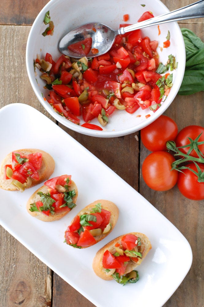 Bruschetta with olives is an AMAZING appetizer and so easy to make. A great use for garden tomatoes and basil.