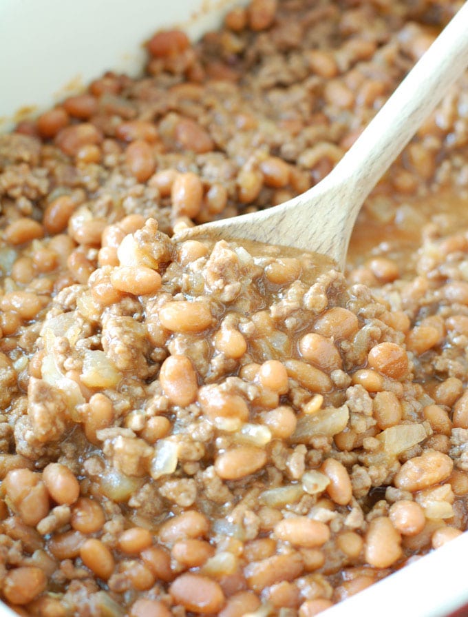 Cowboy Baked Beans Dish with beans and wooden spoon.