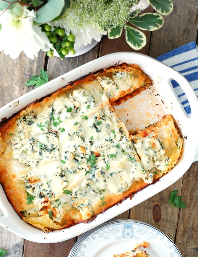 Lasagna in casserole dish with piece missing. 