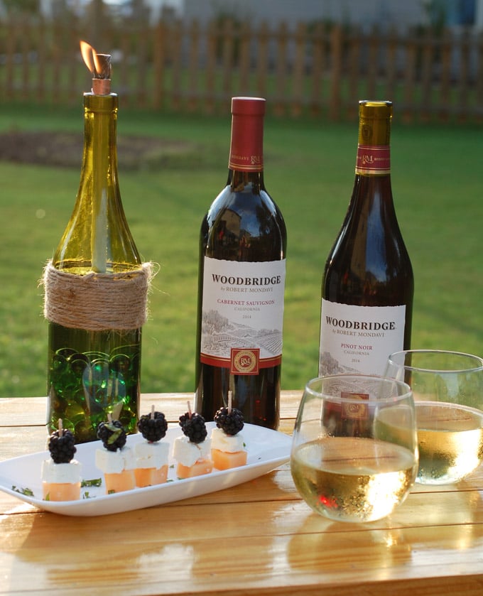 Turn your leftover wine bottles into beautiful backyard DIY wine bottle Tiki torches. They are a perfect way to recycle those old bottles and keep away the bugs from your backyard entertaining area.