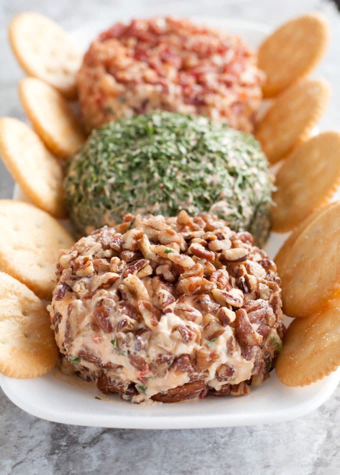 Pecan and chive cheese ball on plate with crackers. 