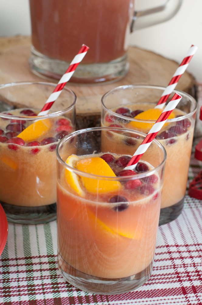 Three glasses of juice with cranberries and oranges. 