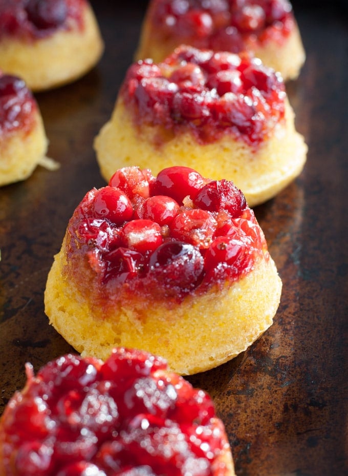 cranberry upside down cake Mini cranberry upside down cakes on a pan.