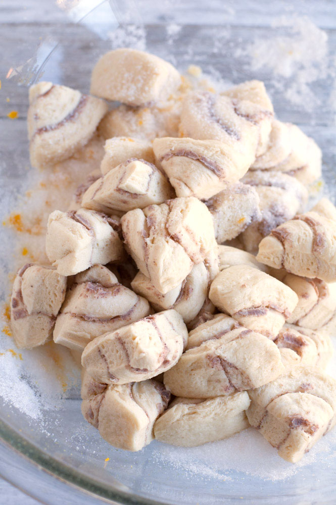 Orange rolls cut up in a bowl