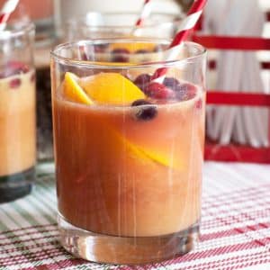 Glass of punch with an orange and straw.