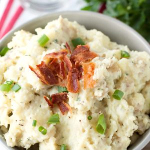 Bowl of mashed potatoes and topped with crumbled bacon.