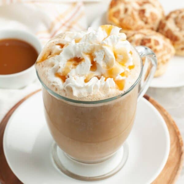 Mug with caramel latte topped with whipped cream.