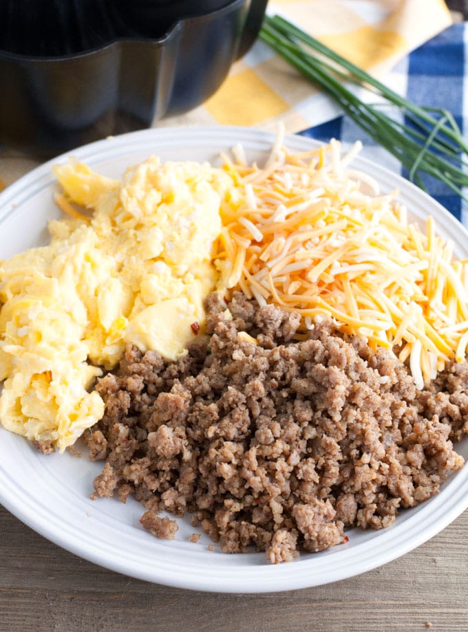 Plate with scrambled eggs, cheese and sausage