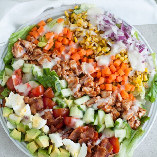 Salad with eggs, bacon, chicken and corn.