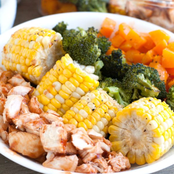 Plate with corn, chopped chicken, broccoli and squash.