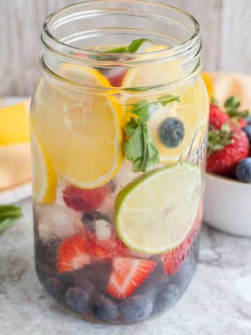 Jar of water with lemon, lime, blueberries and stra