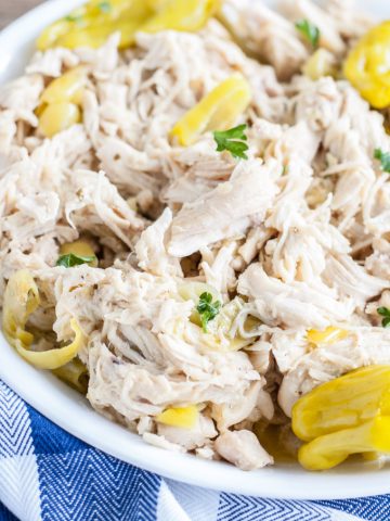 Bowl with shredded chicken and banana peppers.