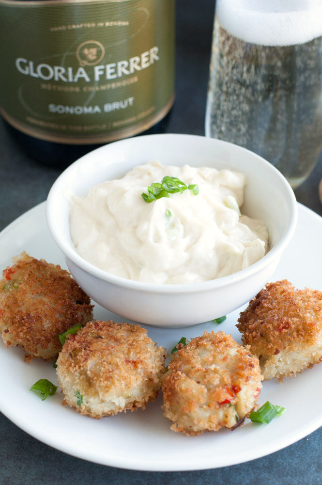 Plate with crab cakes and bowl of white sauce. 