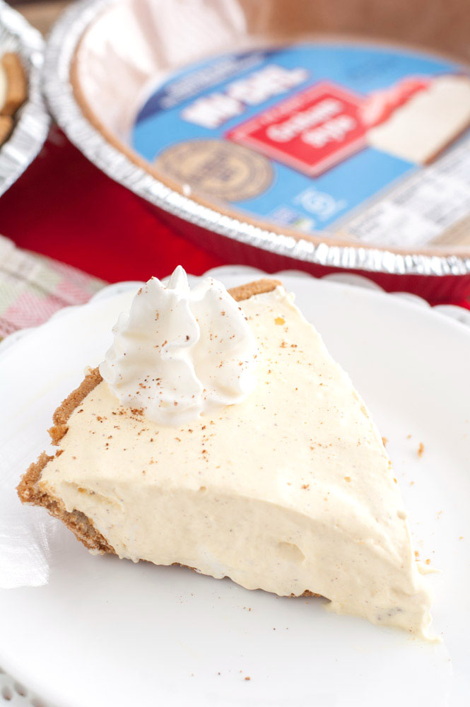 Piece of creamy pie on plate with graham cracker crust. 