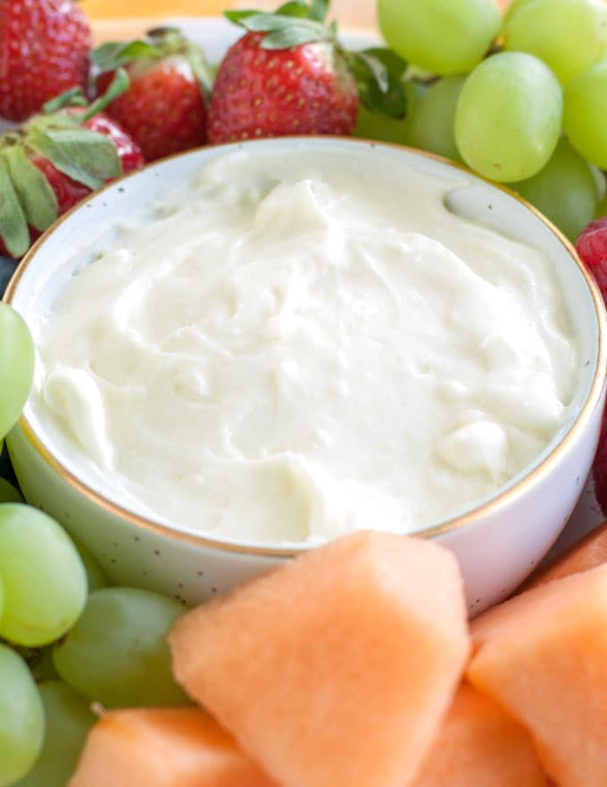 Fruit dip in a bowl surrounded by cut up fruit