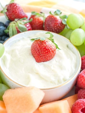 Bowl with creamy fruit dip surrounded by fruit.