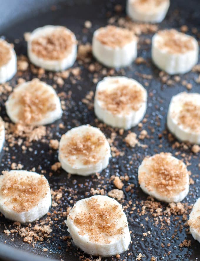 Banana slices topped with brown sugar in a skillet