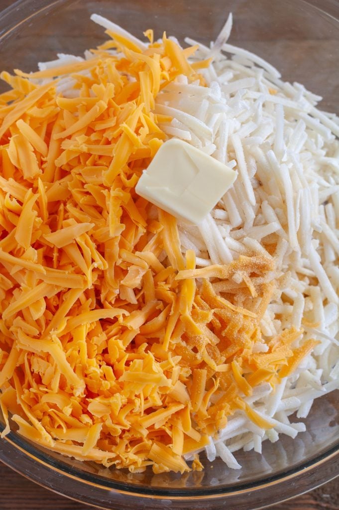 A bowl of cheese, frozen hashbrowns and butter